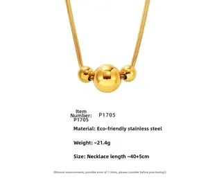 Macro detail of gold stainless steel double chain necklace with three spherical beads