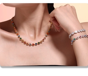 Close-up of elegant gold necklace and bracelets set with vibrant colorful round gemstones