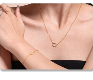 Détail d'une parure en plaqué or 18k avec pendentifs ovales en zircone sur collier et bague