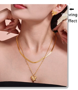 Close-up of double layer gold necklace and heart pearl earrings on model neck