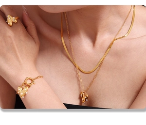 Detail of PVD gold heart jewelry set with faux pearls on necklace, bracelet and ring