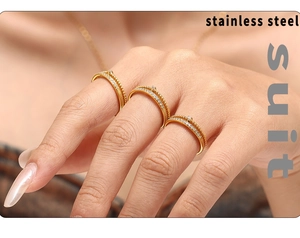 Detailed view of three-piece golden stainless steel rings set with sparkling zircons
