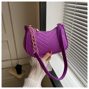 Detail of purple felt half-moon bag featuring V-shaped quilting and golden chain