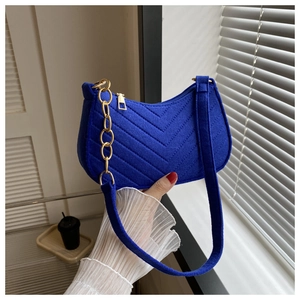 Detail of Klein blue crescent hobo bag with V-shaped quilting and gold chain strap