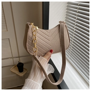 Detail of herringbone wool underarm bag with gold chain and wide shoulder strap