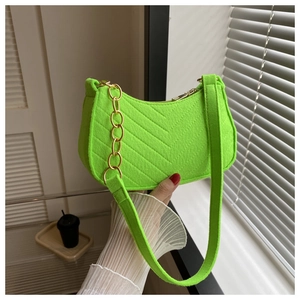 Detail of neon green felt shoulder bag with V-shaped stitching and gold chain decoration