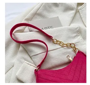 Detail of hot pink V-quilted shoulder bag with gold chain strap and metal zipper