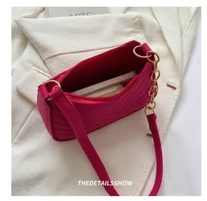 Detail view of fuchsia quilted baguette bag capacity with gold chain and phone inside