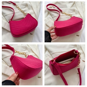 Detail view of fuchsia quilted wool shoulder bag with gold chain and V-shaped stitching