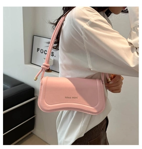 Close-up of pink underarm bag featuring wave bottom design and Miss mini gold logo