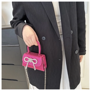 Detail of pink glitter mini bag with sparkling crystal bow and delicate chain strap