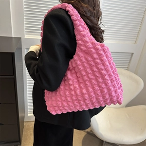 Pink bubble textured large tote bag shown on a model in a minimalist home setting