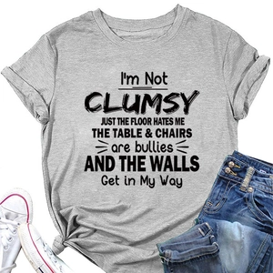 Detailed view of grey t-shirt with I'M NOT CLUMSY slogan paired with blue denim jeans