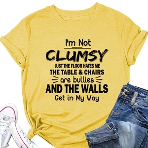Detail of yellow cotton t-shirt with I'M NOT CLUMSY print and decorative hem knot