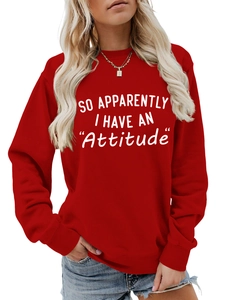 Close-up of 'SO APPARENTLY I HAVE AN Attitude' slogan print on red crewneck sweatshirt