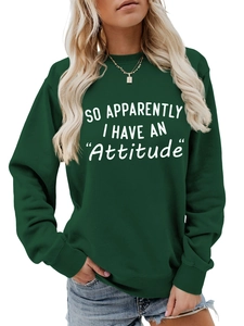 Detail of dark green crewneck sweatshirt featuring white SO APPARENTLY I HAVE AN Attitude print