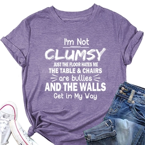 Flat lay of purple cotton T-shirt with white lettering paired with jeans and shoes