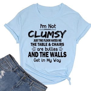 Detail of light blue crew neck T-shirt featuring a humorous I'M NOT CLUMSY print