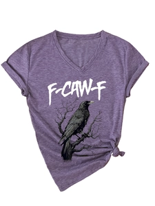 Dettaglio della t-shirt viola con scollo a V, stampa di aquila e nodo sull'orlo
