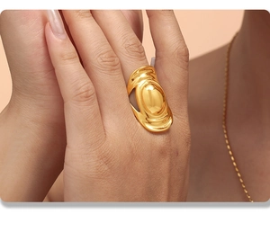 Detail of a large gold oval straw-hat ring with polished mirror finish and wide band