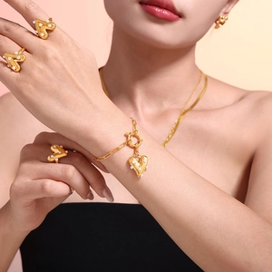 Golden heart jewelry set with pearls including necklace earrings and rings on model