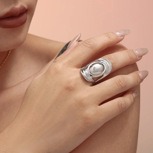 Chic silver oval dome statement ring with wavy band on model against a warm background