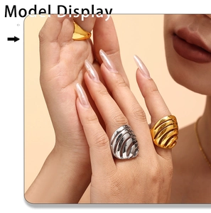 Detailopname van brede gestreepte ringen in goud en zilver aan de hand van model