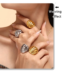 Detailopname van zware spiraalvormige schelpringen in goud en zilver op een model