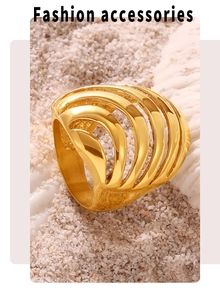 Detail van meerlaagse holle golfring van 18K verguld titaniumstaal op zand achtergrond