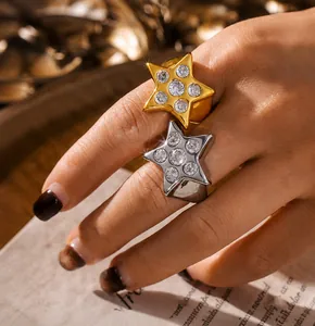Detalle de anillos de estrella dorados y plateados con circonitas sobre papel vintage