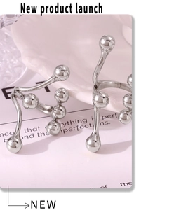 Close-up of minimalist silver rings with branch design and liquid metal spherical detail