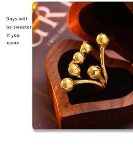 Detailed view of branch-style gold ball ring in a heart-shaped wooden jewelry box