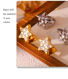 Primer plano de anillos de estrella con circonitas en oro y plata sobre una bandeja