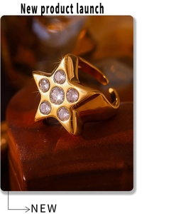Macro de anillo estrella dorado con circonitas incrustadas sobre un joyero de madera