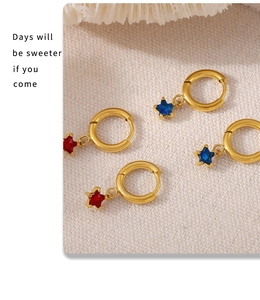 Detailed close-up of gold star earrings featuring vibrant red and blue zircon crystals