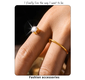 Détail macro d'une bague double dorée en forme de S avec zircon cubique sur la main