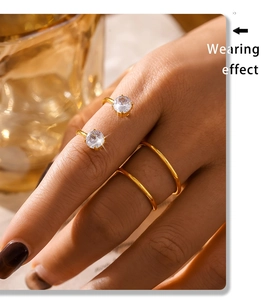 Gros plan d'une bague double couche dorée avec deux zircons clairs sur une main