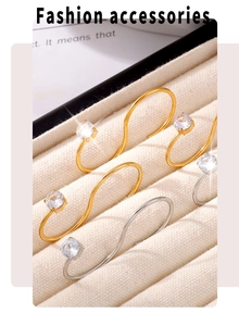 Vue macro de bagues en S dorées et argentées avec zircons sur coffret en velours
