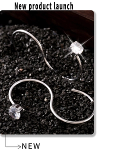 Vue détaillée d'une bague S en argent avec zircone ronde sur fond de pierre noire