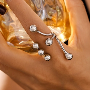 Fluid design silver open ring with polished metal spheres on a model's hand