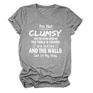 Detailed flat lay of dark grey cotton t-shirt with I'M NOT CLUMSY JUST printed slogan