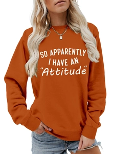 Detail of caramel crewneck sweatshirt featuring white SO APPARENTLY I HAVE AN Attitude print