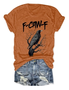 Detail of burnt orange t-shirt with raven graphic and distressed denim shorts set