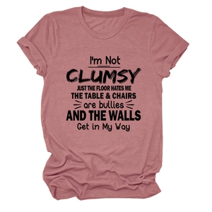 Detail of dust pink round neck T-shirt featuring bold I'M NOT CLUMSY black slogan print