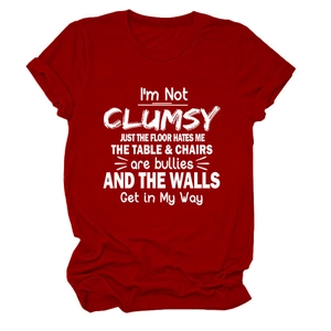 Close-up of soft red cotton fabric with white 'I'M NOT CLUMSY' slogan print on a t-shirt