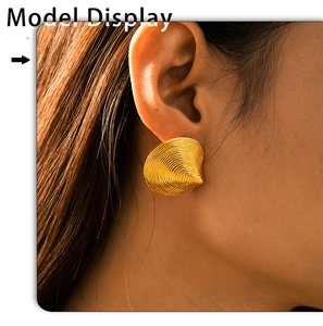 Makroaufnahme von goldenem Muschelohrring mit detaillierter Spiralstruktur am Model