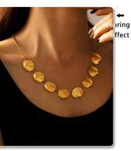 Detailansicht einer goldenen Muschelhalskette mit strahlenden runden Sonnenanhängern