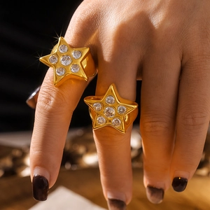 Elegantes anillos de titanio dorado con forma de estrella y circonitas en dedo