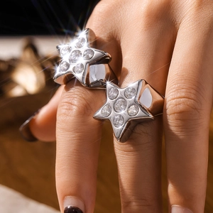Anillos de estrella dorada con circonitas mostrados en una pose elegante de estilo de vida