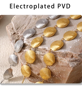 Nahaufnahme von PVD-vergoldeten Muschelhalsketten mit Spiraltextur auf Felsuntergrund